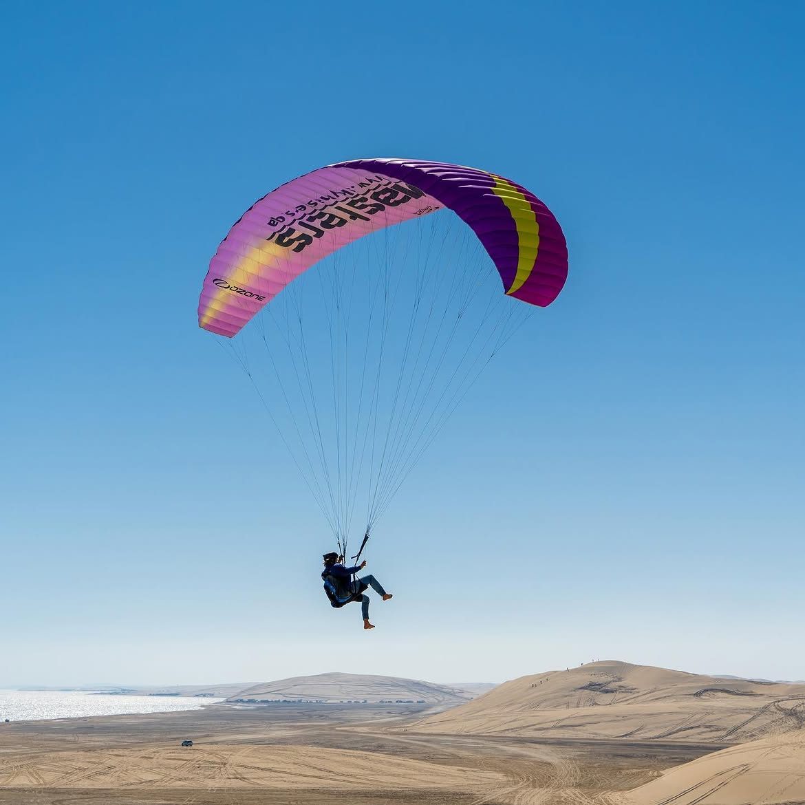 A magenta Skymasters wing soaring over the dunes