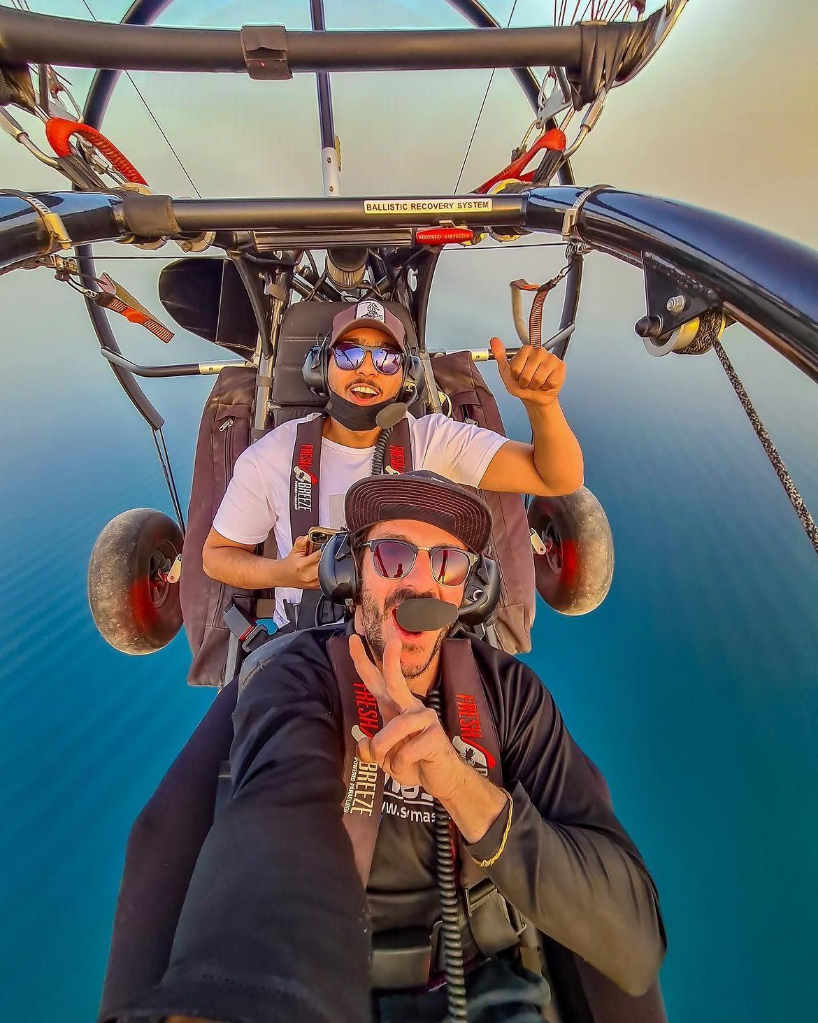 Javi flying a paratrike with a young passenger